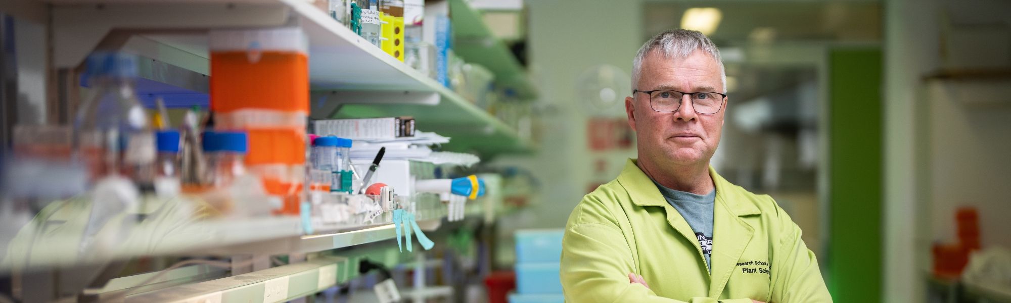 A man standing confidently in a well-equipped laboratory, looking at laboratory supplies