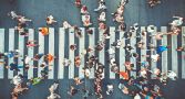 An aerial view of a crowd of people crossing a pedestrian crosswalk