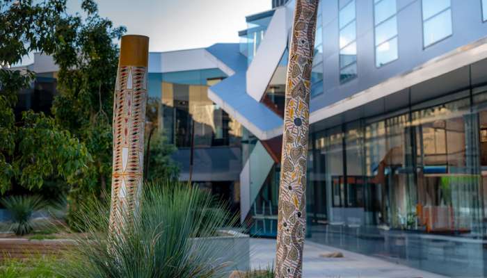 Image: Memorial and burial poles from Galiwin’ku installed at the John Curtin School of Medical Research. Photo by Jamie Kidston/ANU.